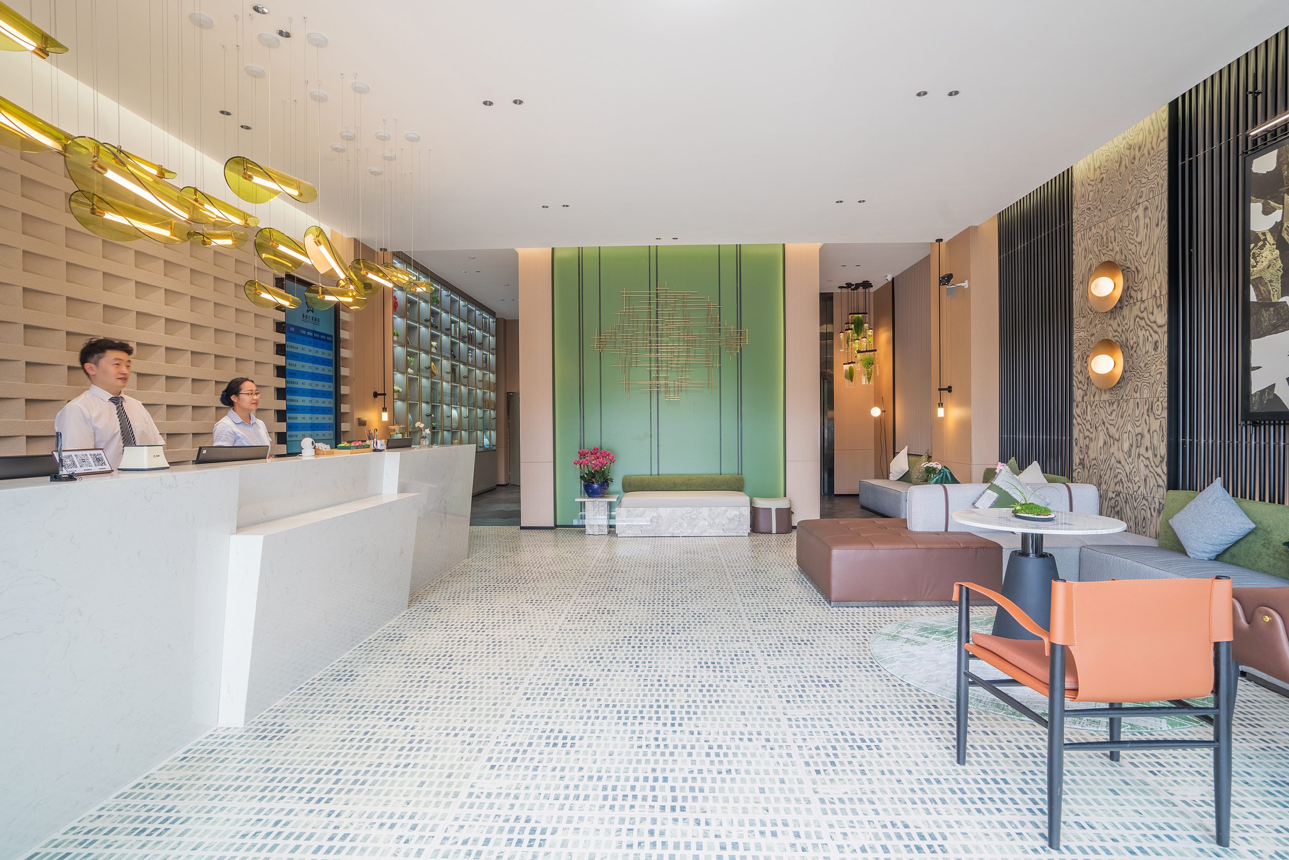 Hotel lobby and reception at Spring City Star Boutique Hotel with signature lighting, green accent wall, and seating area.