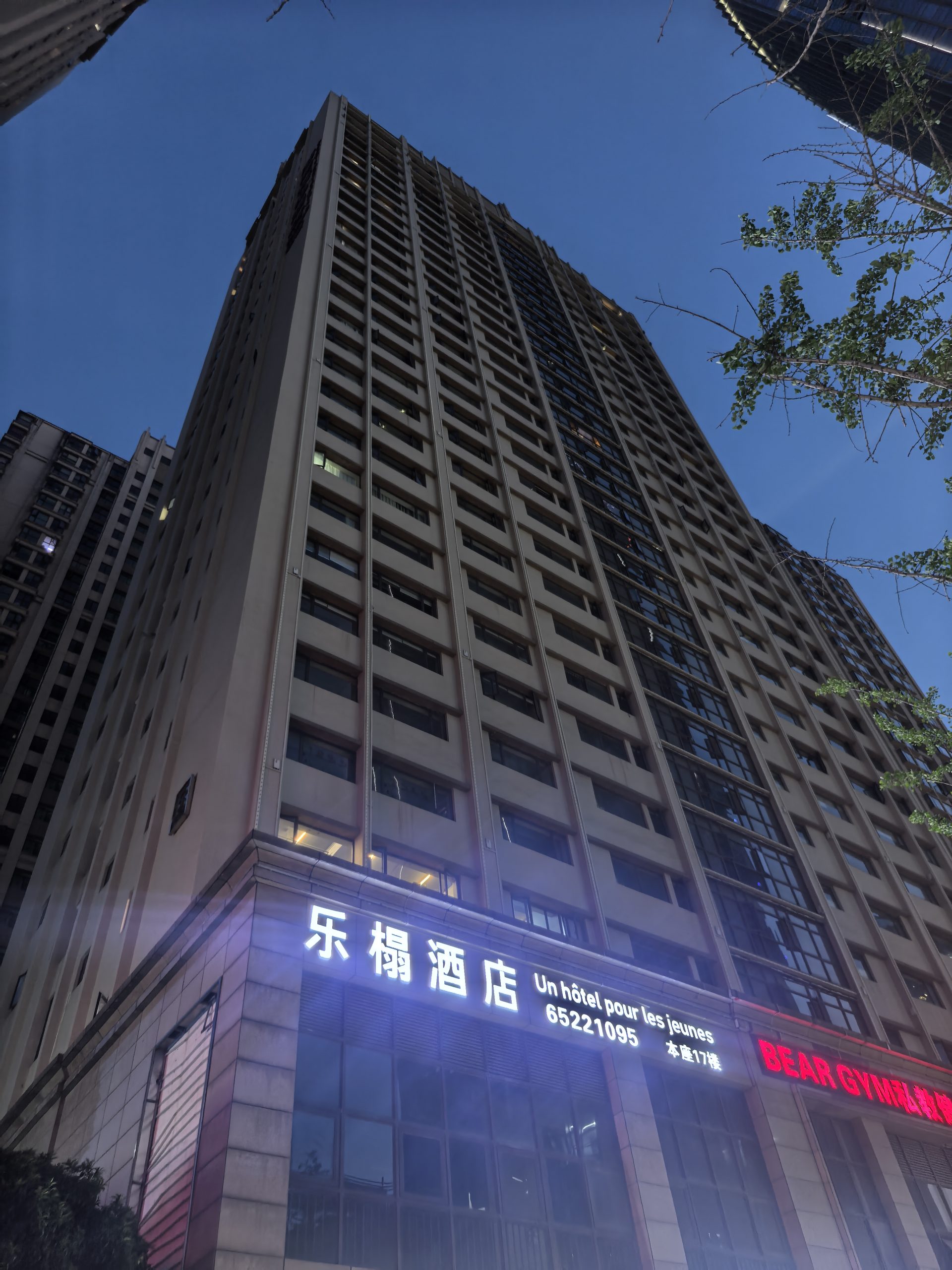 L'Hôtel 乐榻酒店 Kunming night exterior – Spring City Star high-rise tower with illuminated French signage at dusk